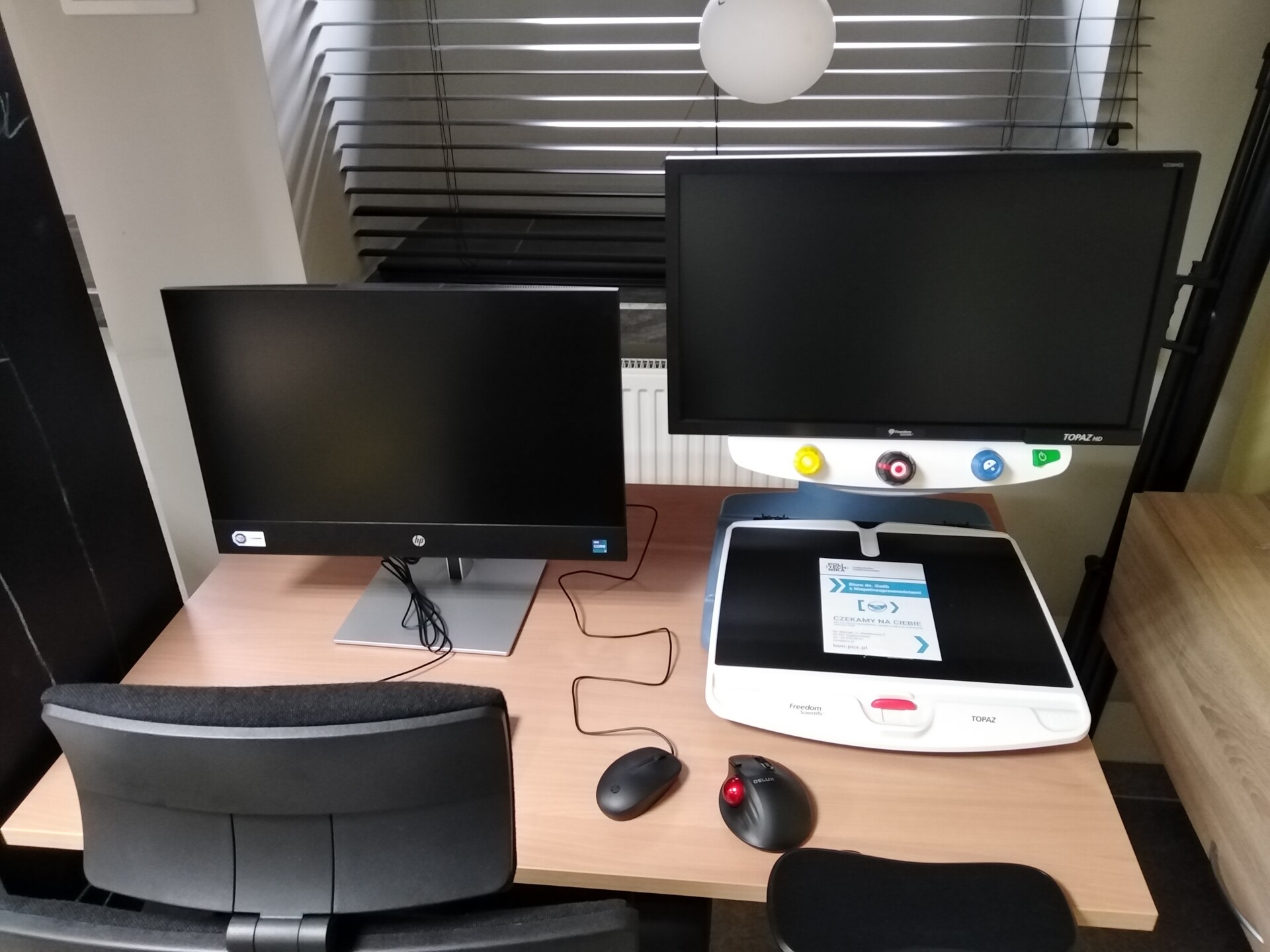 monitor i powiększalnik ustawione na biurku z regulacją wysokości